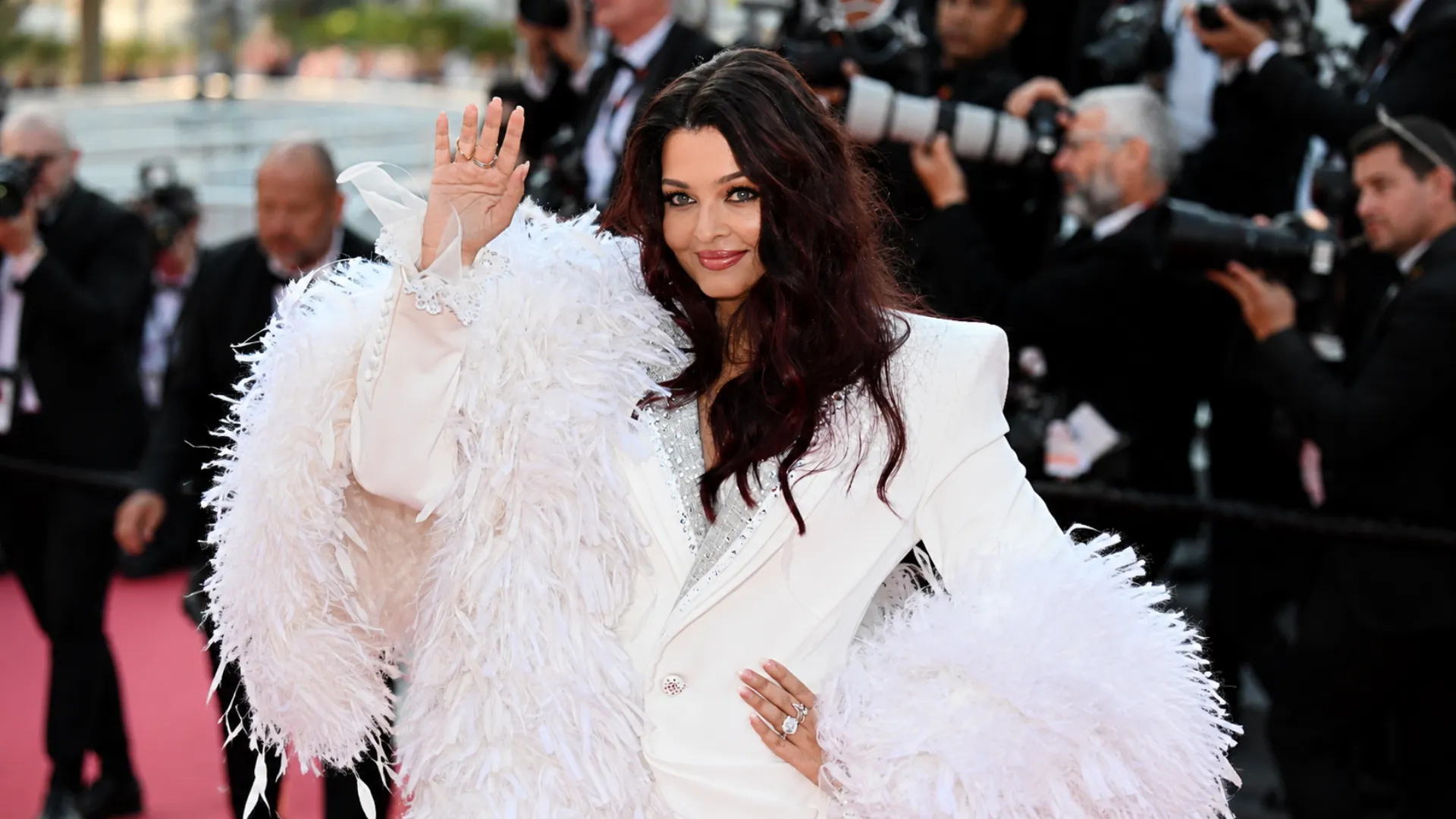 Aishwarya Rai Bachchan posing in a dramatic white 3D floral couture gown with oversized rose ruffles on the French Riviera at Cannes 2026.